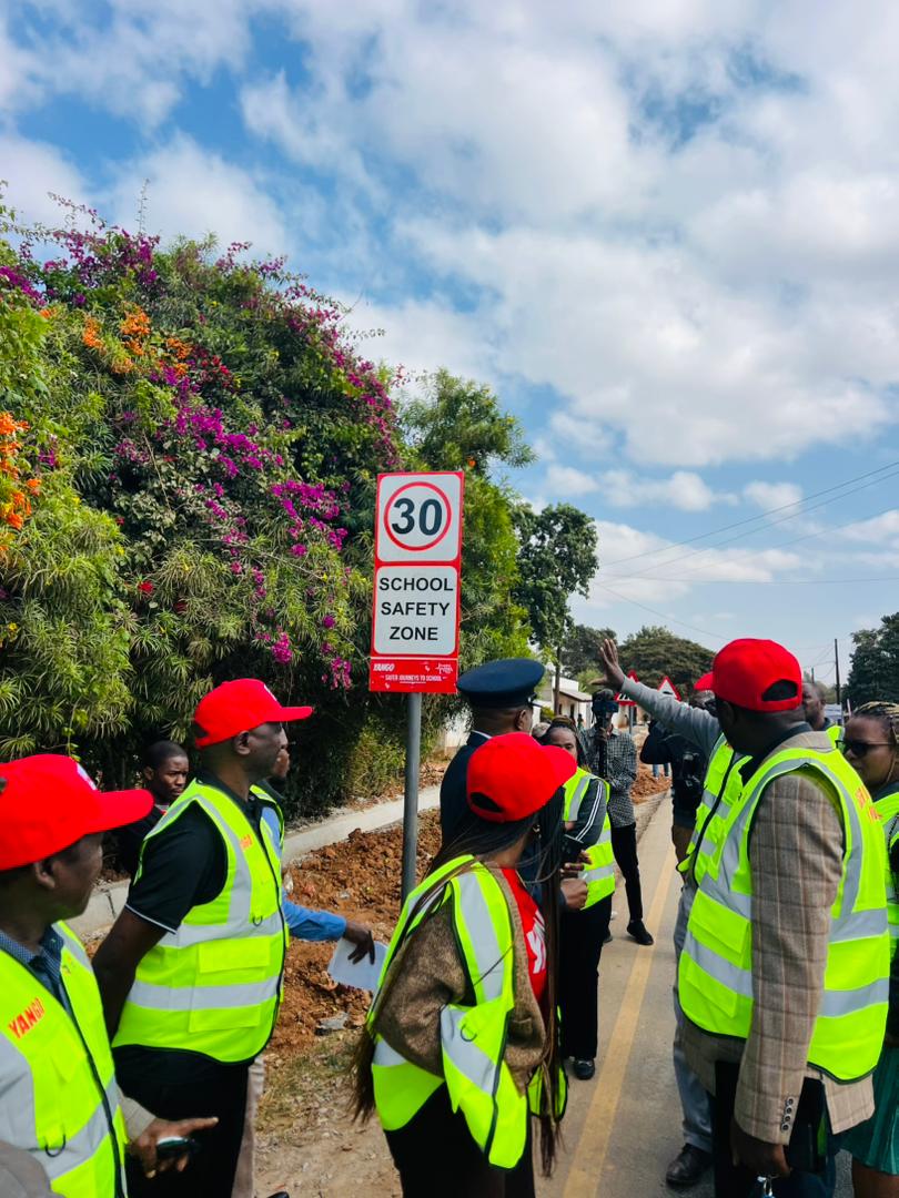 Institutional representatives holding a 30 kilometre per hour School Safety Zone sign