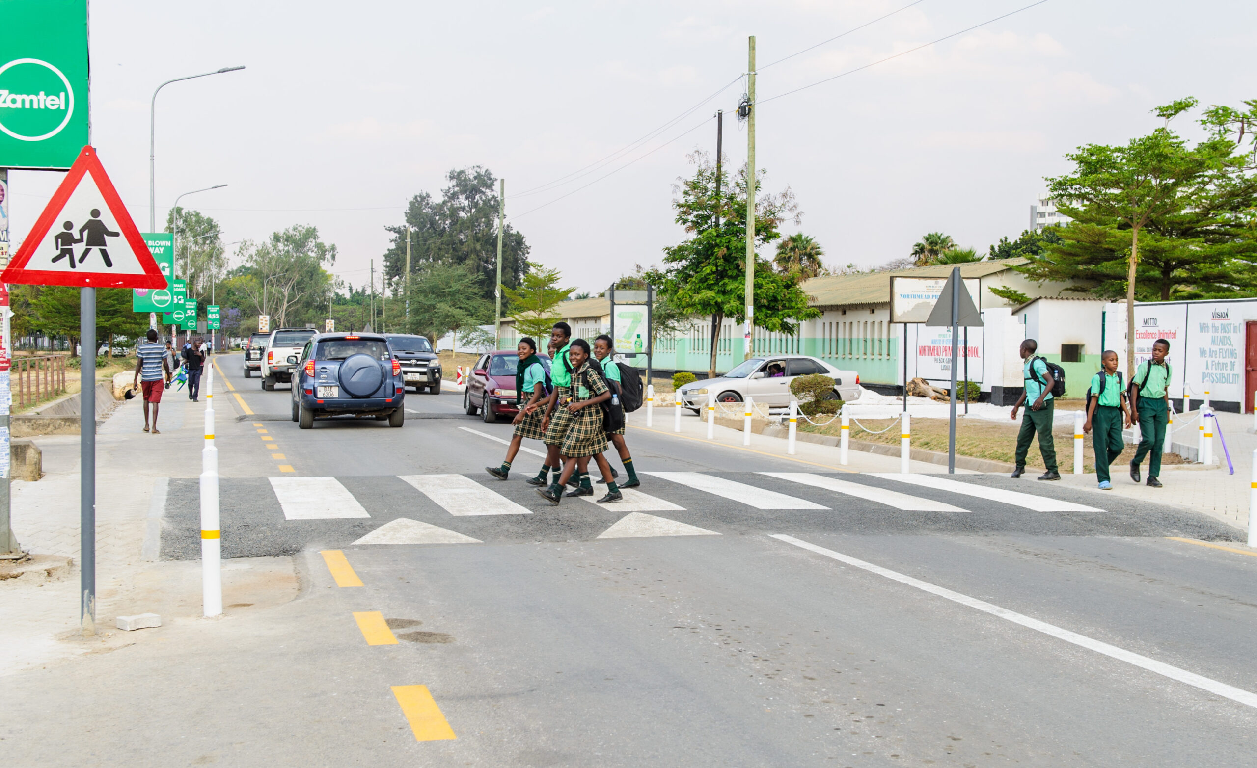 Learners crossing a marked zebra crossing outside Northmead Primary School a ZRST-supported school